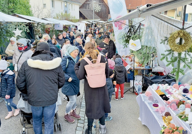 Viele Personen spazieren entlang den bunt gemischten Weihnachtsständen. Ian Stewart
