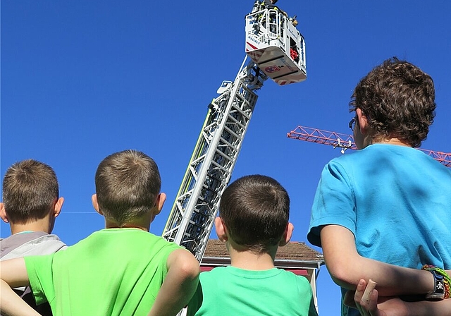 Der Nachwuchs beobachtet fasziniert einen Rettungs- und Löscheinsatz mit der Autodrehleiter.An diesem Posten zeigten die Feuerwehrleute dem interessierten Publikum einen Bergungseinsatz bei einem Autounfall.Mit dem Hydroschild wird verhindert, dass 