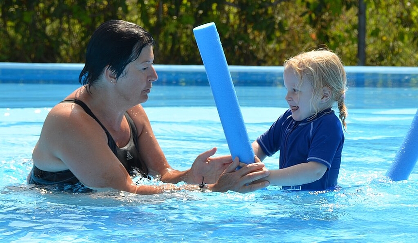 Schwimmlehrerin Doris Schmid instruiert die kleine Emilia zum «Reiten.