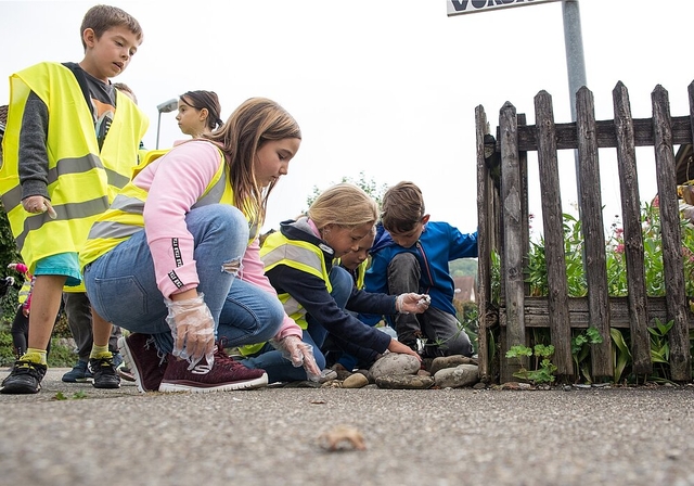 Die Kinder schauen ganz genau hin: Überall versteckt sich Abfall auf den Quartierstrassen. (Barbara Scherer)
