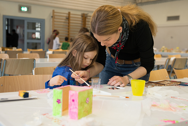 Eltern bastlen mit ihren Kindern.
