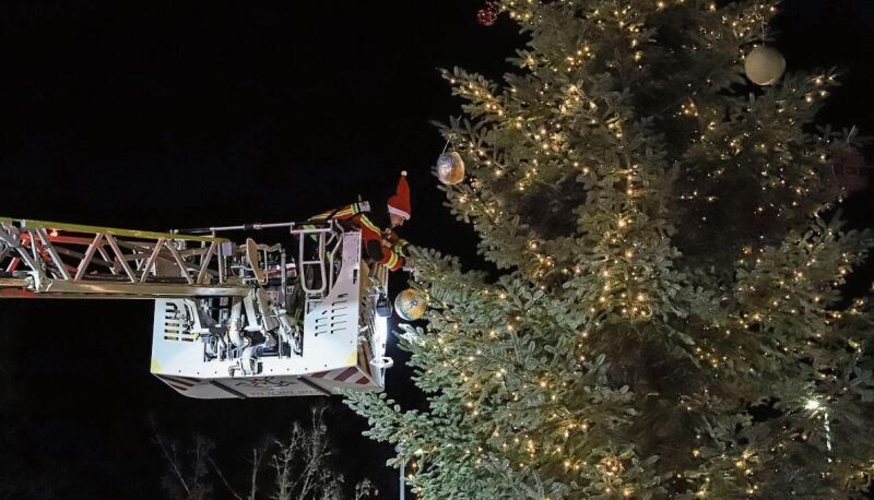 Die Feuerwehr schmückt mit Hilfe der Drehleiter den Weihnachtsbaum auf dem Gemeindeplatz.  Gaby Kost