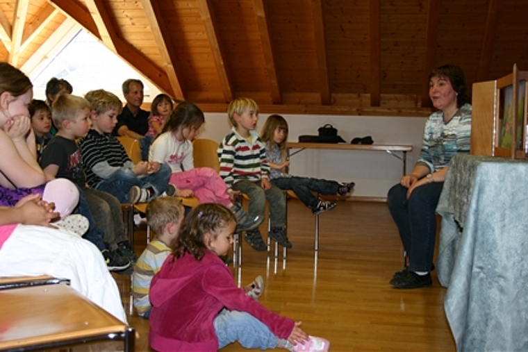 Gespannt lauschen die Kinder der Erzählung von Anita Szasz und betrachten die Bilder im Holzkoffer.Foto: mbo