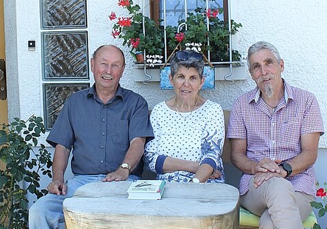 Fritz und Anita Voser mit Peter Truniger vor ihrem Haus in Neuenhof. Die Schwalbennester befinden sich über ihren Köpfen. Rahel Bühler
