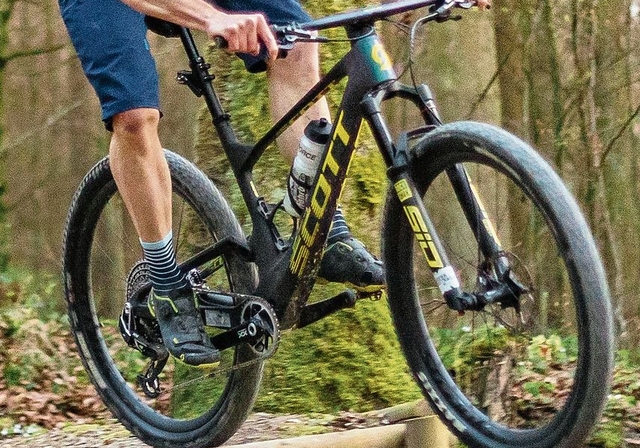 Markus Roth fährt auf einem Singletrail über ein Hindernis. Piotr Piwowarski