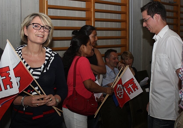 Elke Busse (l.) freut sich über ihre Einbürgerung und die Fahnen der Gemeinde.bär