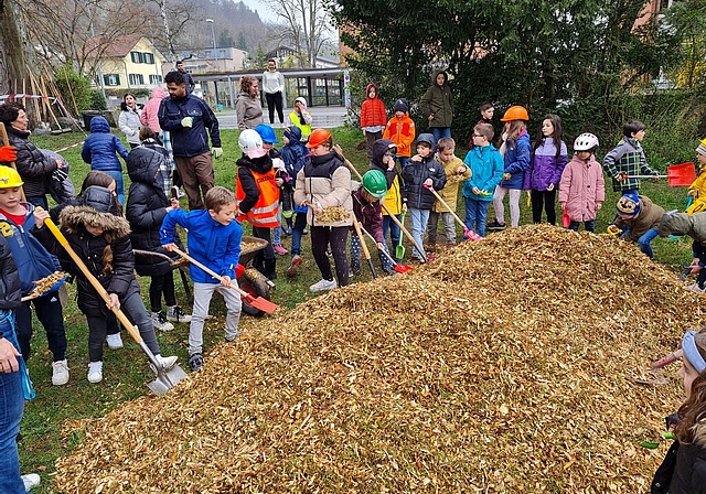 Die Primarschüler laden Holzschnitzel auf die Schaufeln. Schon im Mai sollen die Kinder auf dem neuen Spielplatz spielen können. 