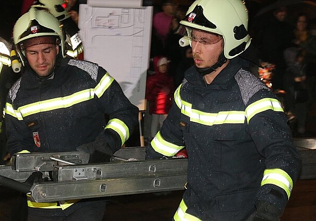 Mit der Leiter holen die Feuerwehrmänner die eingeschlossenen Bewohner aus dem Mehrfamilienhaus an der Dorfstrasse 1. Melanie Bär
