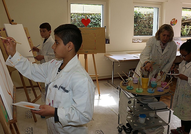 Nouraldin, Axad und Naaema (v.l.) mit Alice Tassinari in den Räumlichkeiten der Reformierten Kirchgemeinde. bär