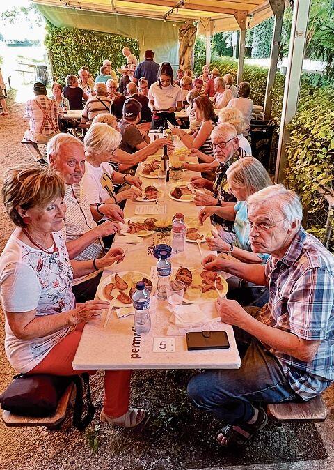 Eine Wettinger Tafelrunde geniesst die frisch zubereiteten Zanderfilets.gk