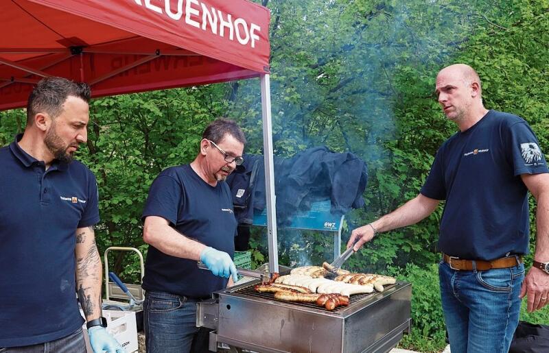 Die Neuenhofer Feuerwehrmänner grillieren Würste für die Anwesenden.gk