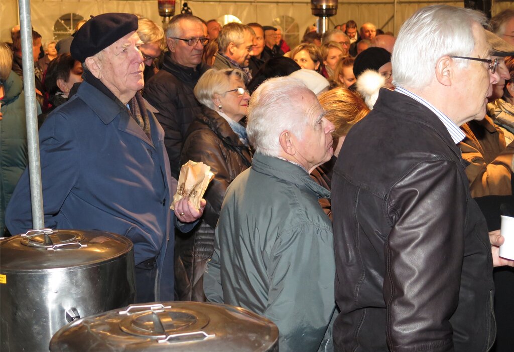 Aufmerksame Zuhörer bei Glühwein und Marroni.
